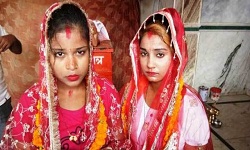 Two girls exchange garlands, apply vermilion at Varanasi temple